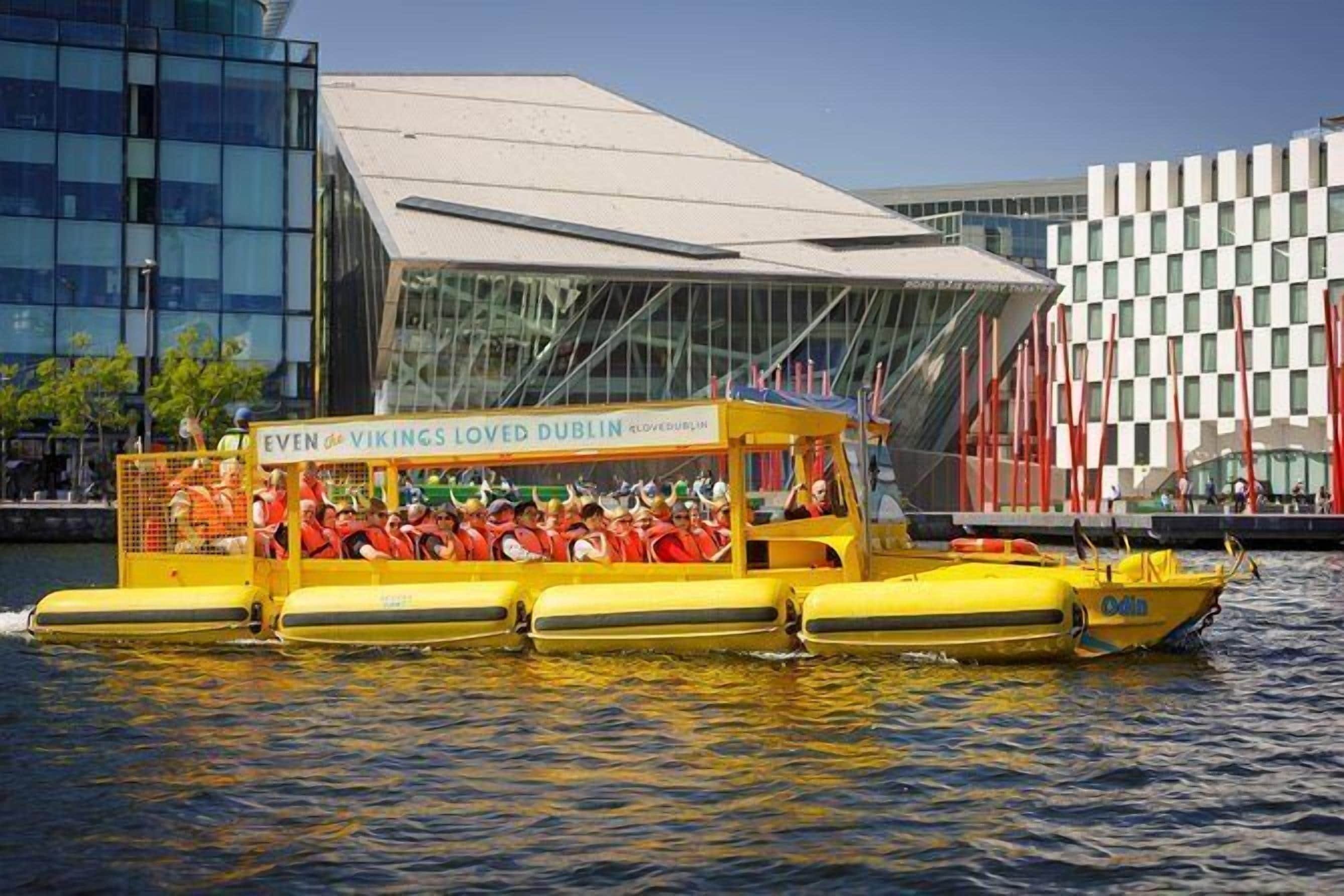 A yellow boat with a sign reading "Even the Vikings Loved Dublin" on the water.