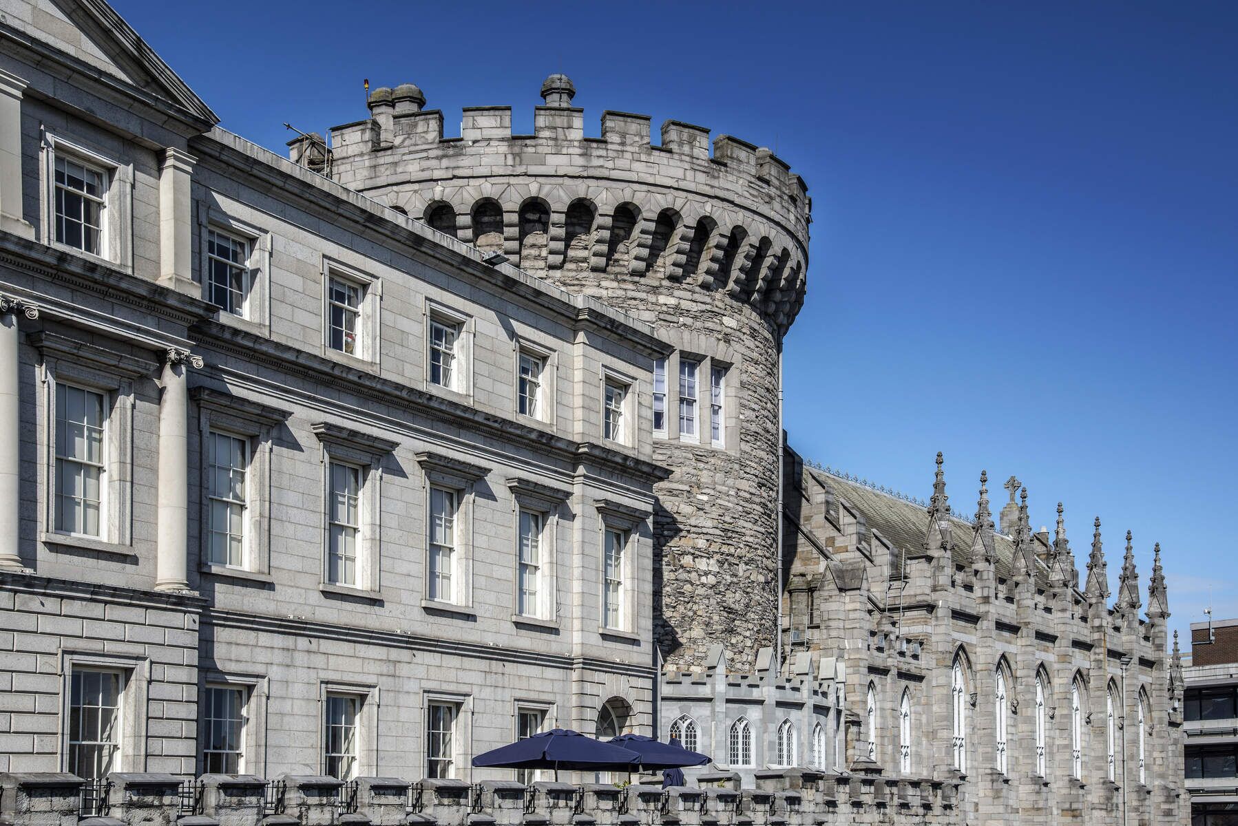 A historic building with a prominent stone tower and arched windows.