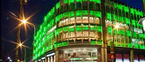 A building with a green-lit facade and a dome structure.