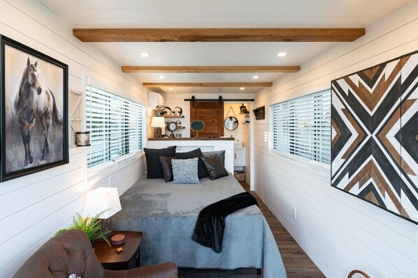 A cozy interior with a bed, a seating area, and a dining space.