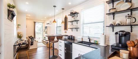 Een moderne keuken met een centraal eiland, hanglampen en inbouwplanken.