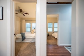 Un dormitorio con cama, ventilador de techo y ventana.