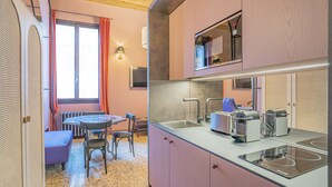 A compact kitchen with a dining area, equipped with a sink, toaster, and kettle. - Corte Rubbi 5 Deluxe Studio-Apartment (Venice)