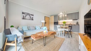 Un salon moderne avec un canapé, une table basse et un coin repas.