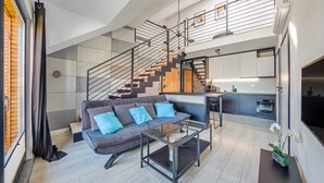 Ein modernes Wohnzimmer mit Sofa, Couchtisch und einer Treppe zu einer oberen Ebene.