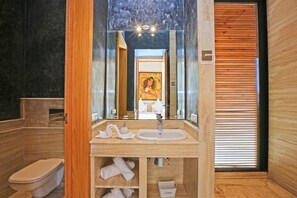 Een moderne badkamer met een grote spiegel, een wastafel en een toilet.