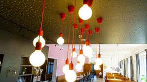 A restaurant interior with hanging spherical light fixtures and a long dining area.