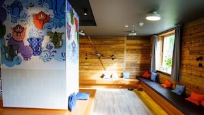 A room with a wooden wall, a white brick wall, and a window with curtains.