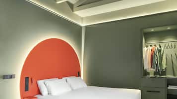 Un dormitorio moderno con cama, un cabecero circular, un armario y un espejo.