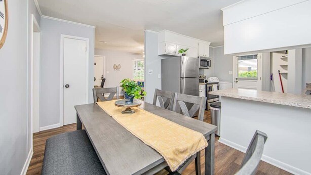 A modern kitchen with white cabinets, a stainless steel refrigerator, and a microwave.
