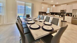 A modern kitchen with white cabinets, a microwave, and a refrigerator.