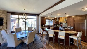 A spacious kitchen with a large island, wooden cabinets, and modern appliances.