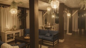 Een gezellige kamer met een blauwe bank, houten meubels en hangende kristallen kroonluchters.