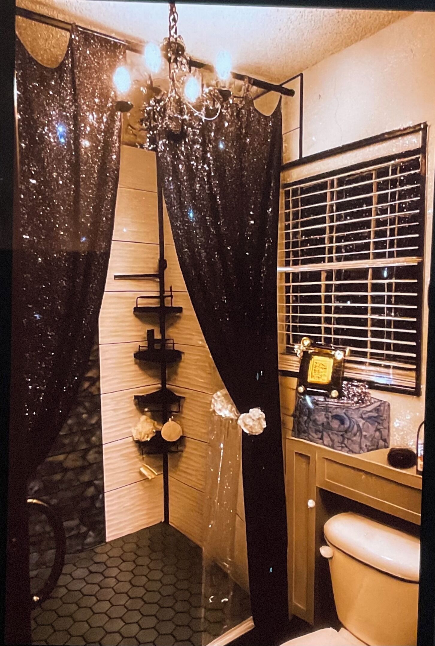 A bathroom with a shower curtain, a toilet, a sink, and a mirror.