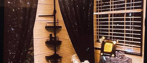 A bathroom with a shower curtain, a toilet, a sink, and a mirror.
