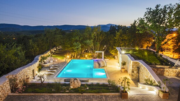 A swimming pool with lounge chairs and a stone wall surrounding it, set against a mountainous backdrop. - Villa with stunning underwater view, fenced private park (Imotski)