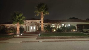 A two-story house with a central entrance, a garage, and a driveway. - Rancho Encantado VIP (El Paso)