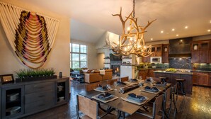 Une cuisine moderne dotée d’un îlot central, de meubles en bois et d’un lustre.