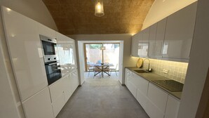 A modern kitchen with white cabinets, a built-in oven, and a sink. - Townhouse Cas Concos Santany (Cas Concos des Cavaller)