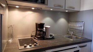 Una cocina moderna con estufa integrada, cafetera y pileta.