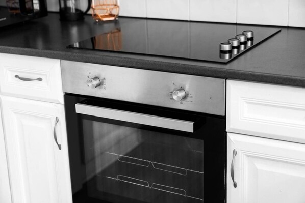 A kitchen with a built-in oven, a stovetop with four burners, and a stainless steel range hood.