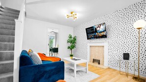 Ein modernes Wohnzimmer mit einem blauen Sofa, einem weißen Couchtisch und einem Kamin.