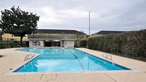 Une piscine rectangulaire, avec un poste de surveillance pour les sauveteurs en arrière-plan.