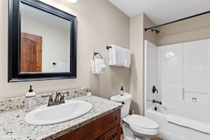 Une salle de bain avec un meuble-lavabo à deux vasques, des toilettes et une baignoire.