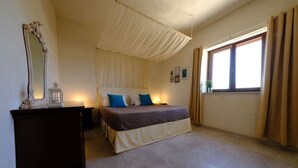 Un dormitorio con cama, un espejo grande, una mesita de noche y una ventana con cortinas.