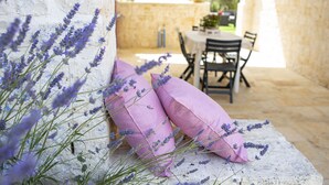 A stone bench with lavender plants and pink cushions in a rustic outdoor setting. - ancient villa converted into a luxury residence by pugliadamare (Martina Franca)