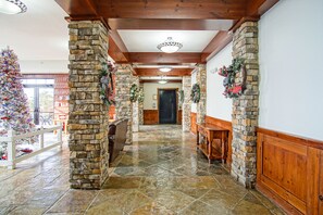 Stroll through this cozy hallway, featuring a fireplace and a bench, leading to a door and a beautifully decorated space.