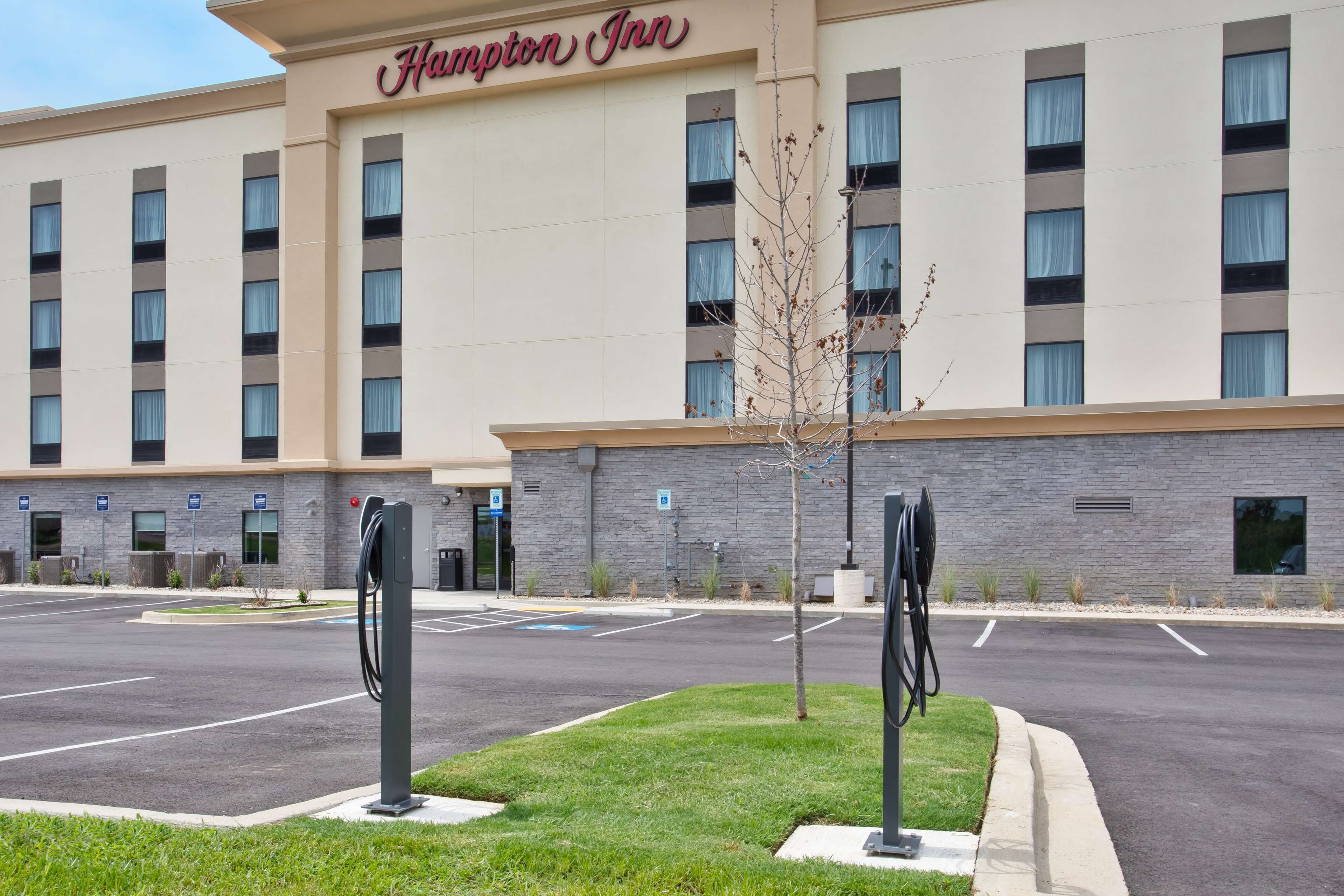 Un hotel Hampton Inn con aparcamiento y estaciones de carga para vehículos eléctricos.