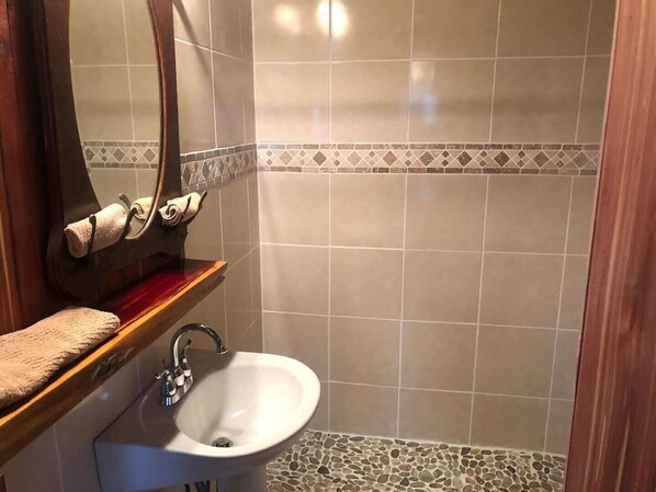 A bathroom with a sink, mirror, and towel rack.