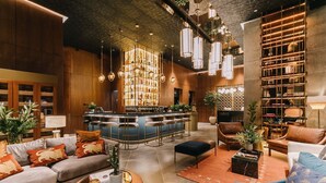 Un área de bar moderna con barra, asientos y una lámpara decorativa.