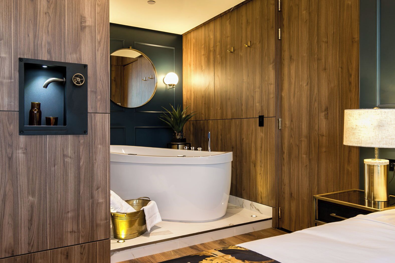 A modern bathroom with a freestanding bathtub, a mirror, and a small shelf with toiletries.