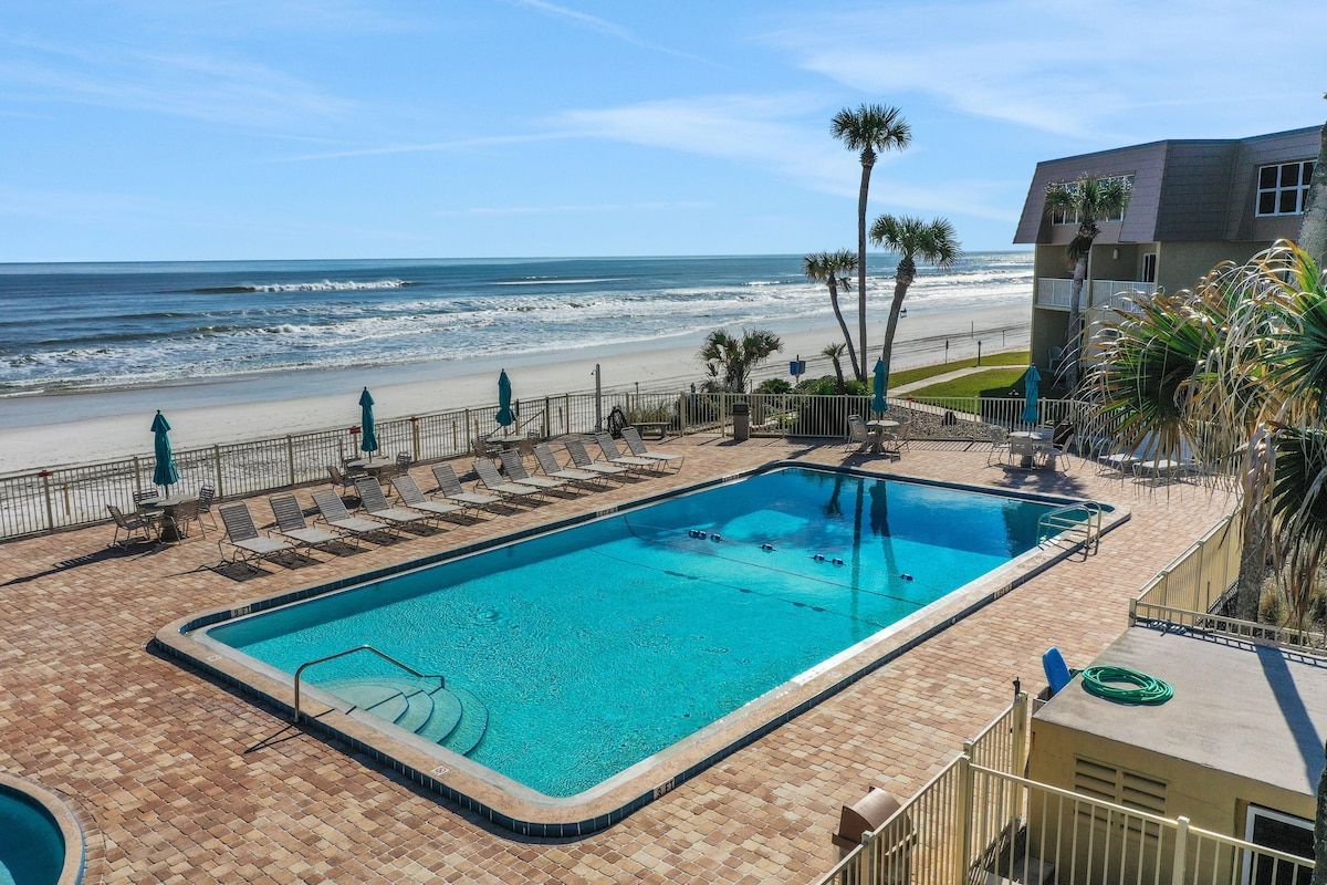 A swimming pool with a view of the beach and ocean.
