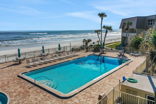 A swimming pool with a view of the beach and ocean.