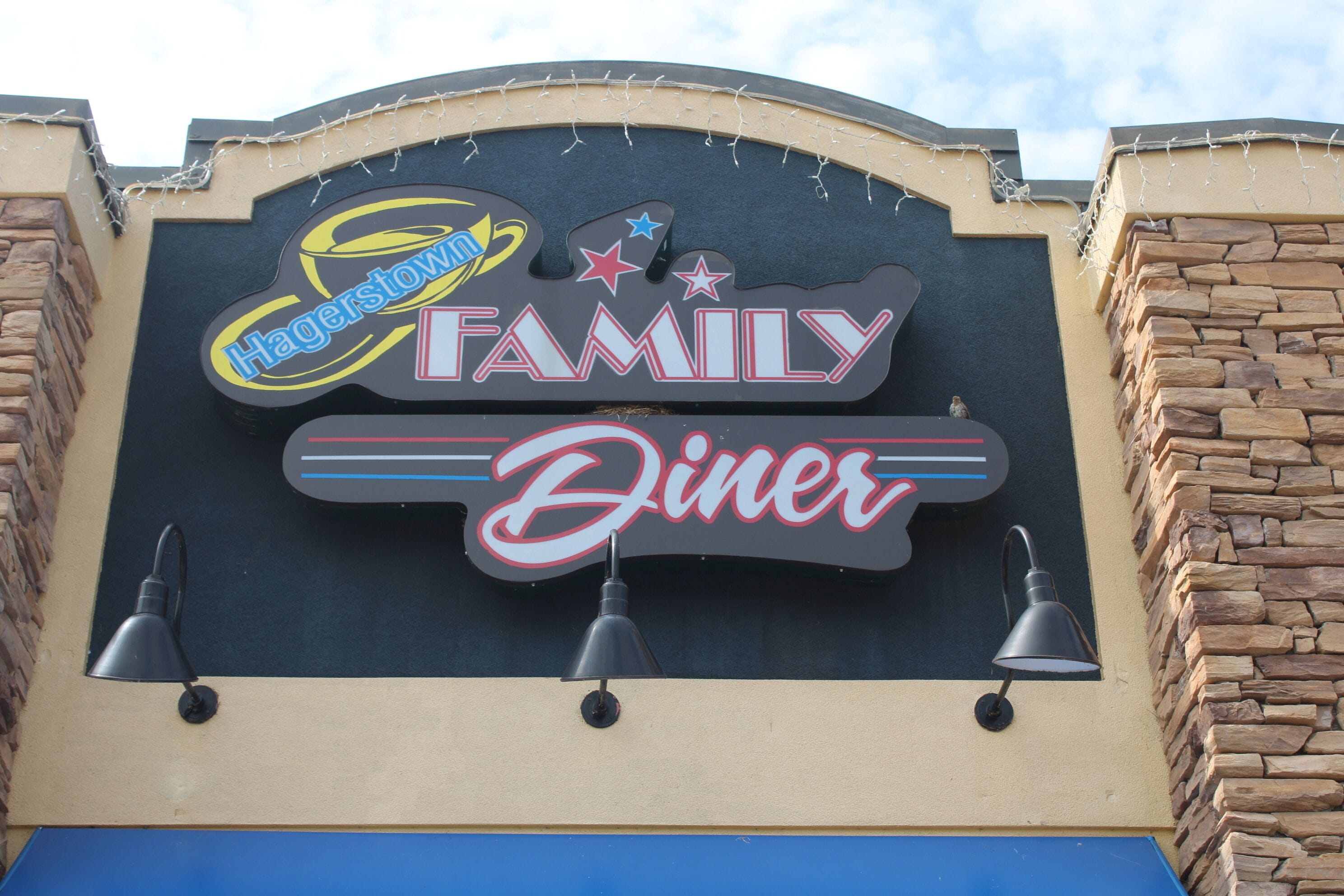 Placa do Hagerstown Family Diner, com letreiro de neon e três luminárias pendentes.