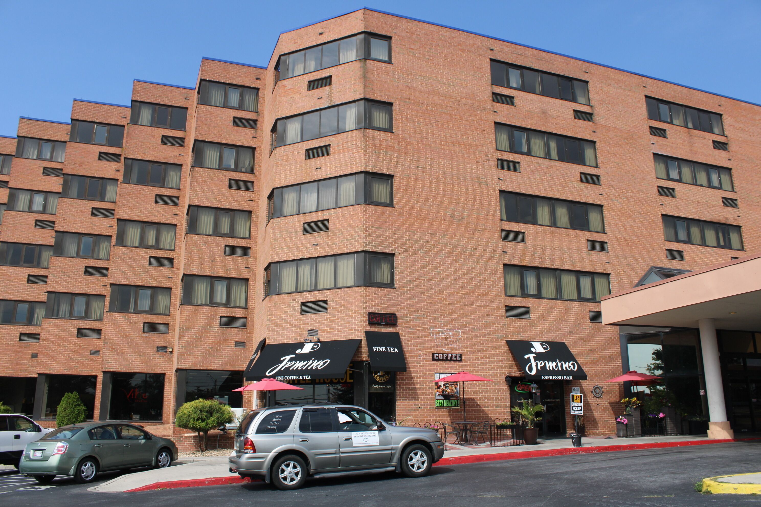 A multi-story brick building with a coffee shop named "Timmins" on the ground floor.