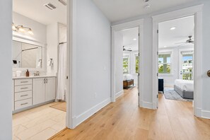 A modern interior with a bathroom, a bedroom, and a hallway.
