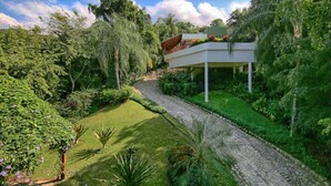 A modern house with a garden pathway leading to a covered outdoor area.