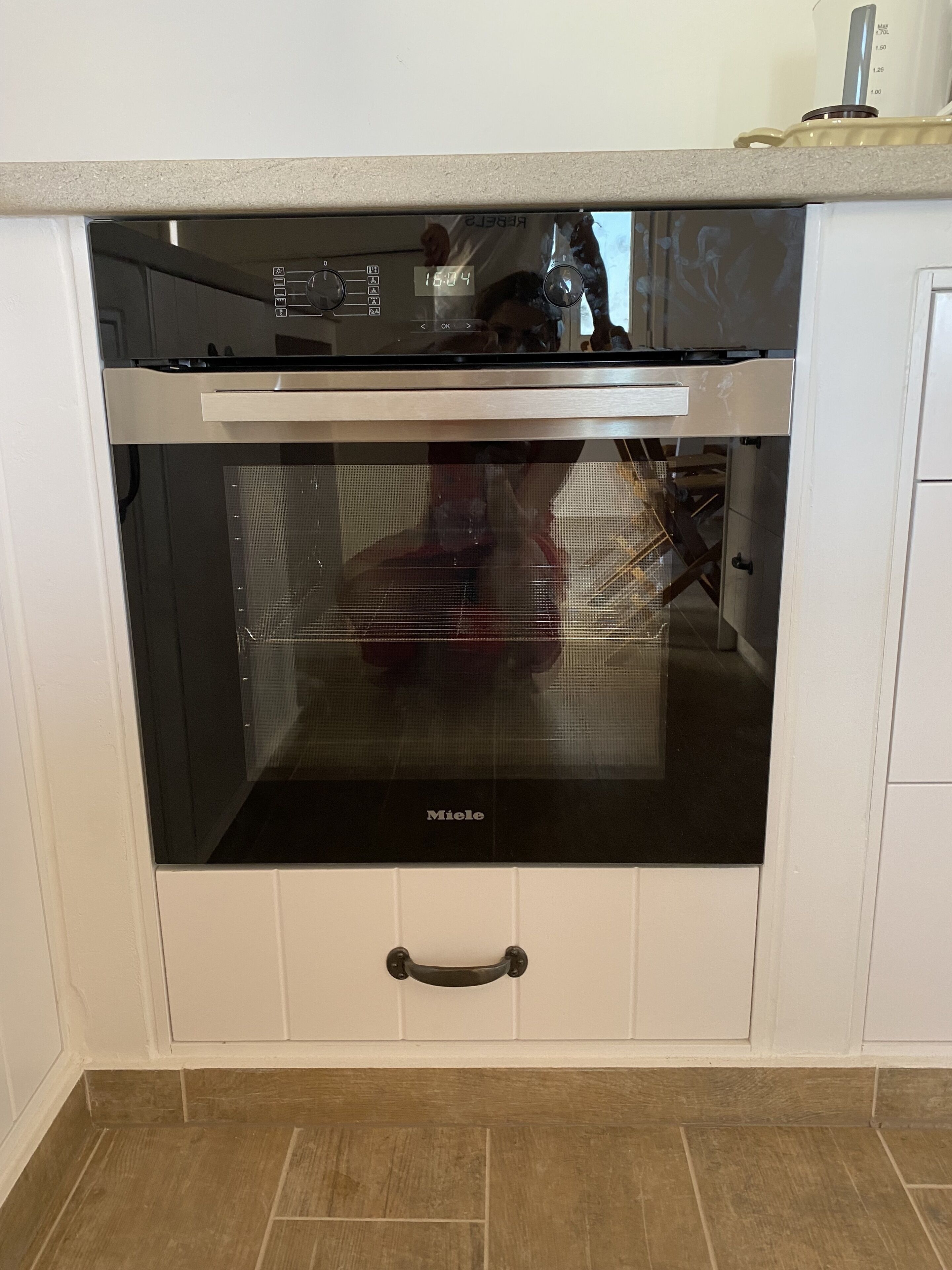 A kitchen with a built-in oven, a microwave, and a coffee maker on the countertop.