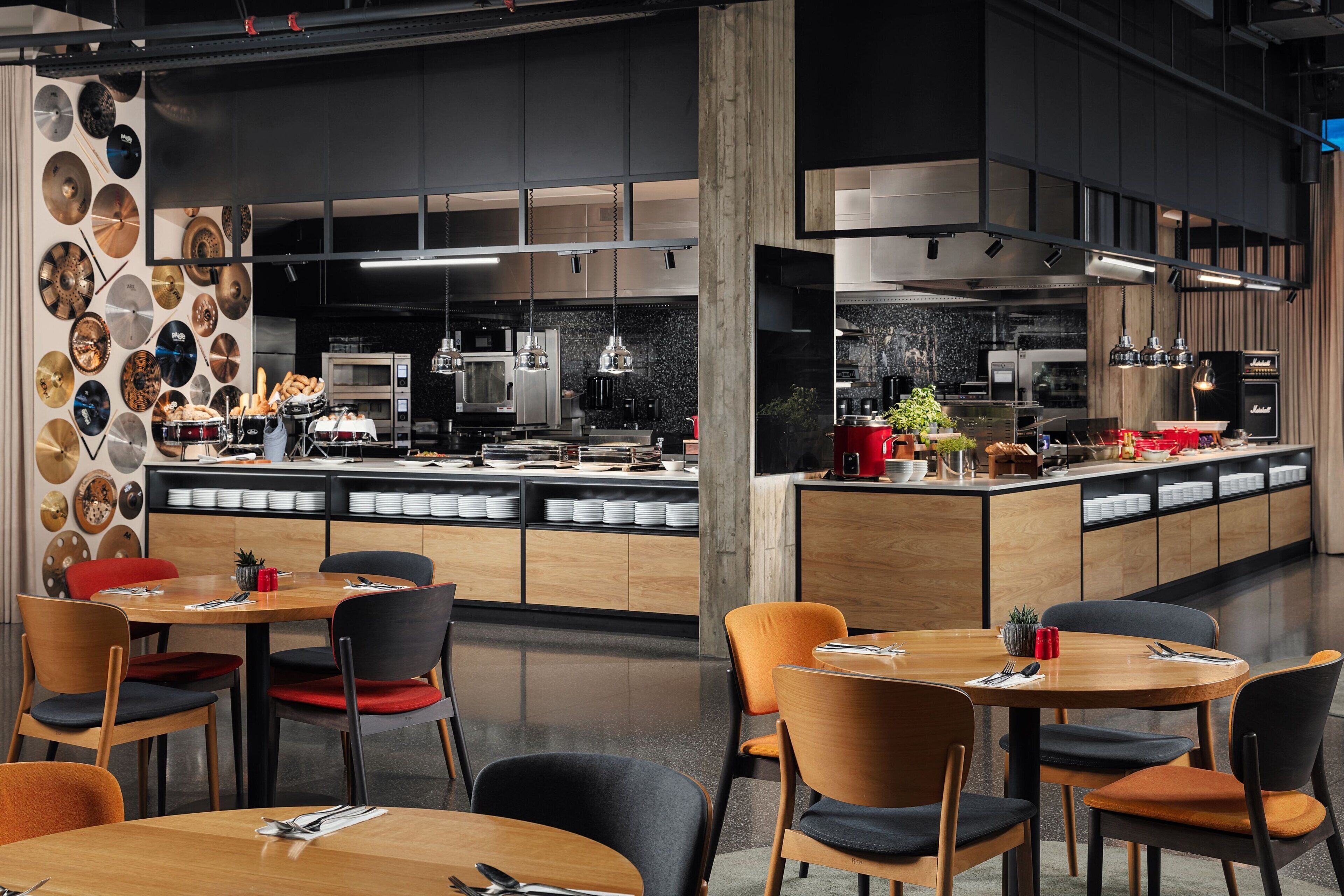 A modern restaurant with a central island, wooden tables, and chairs.