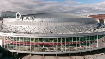 Un estadio grande y moderno con una estructura de techo distintiva y fachada de vidrio.