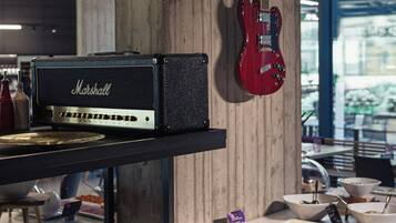 Ett område med en buffé där det finns ett stort utbud av mat, en Marshall-förstärkare och en röd gitarr som hänger på väggen.