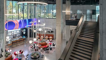 Um hall espaçoso com área de estar central, um bar e uma escadaria.