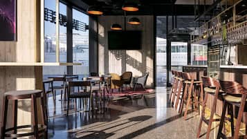 Un espace bar moderne avec des meubles en bois, un téléviseur à écran plat et une rambarde en verre.