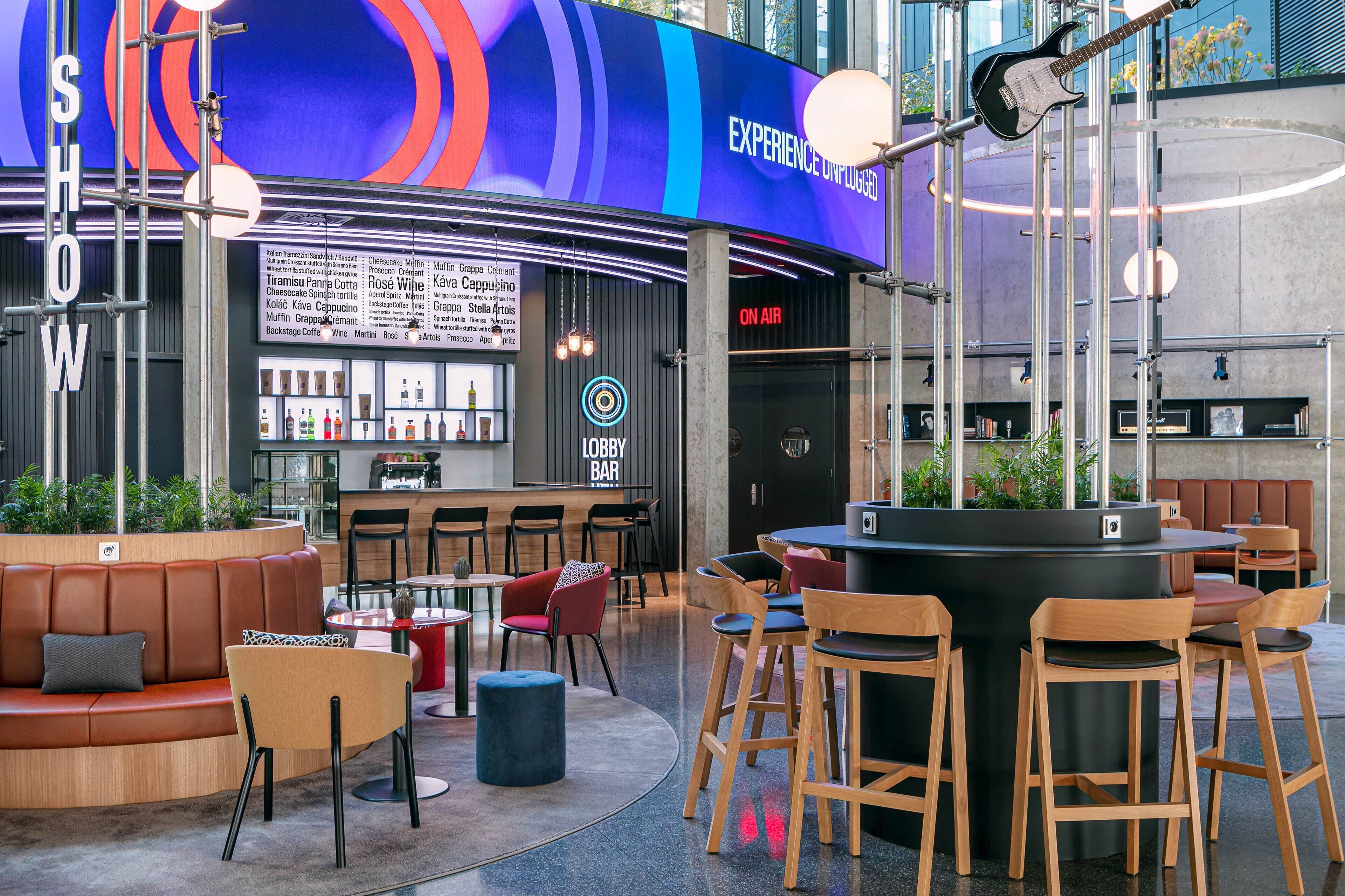 A modern lounge area with seating, a bar, and a menu board.