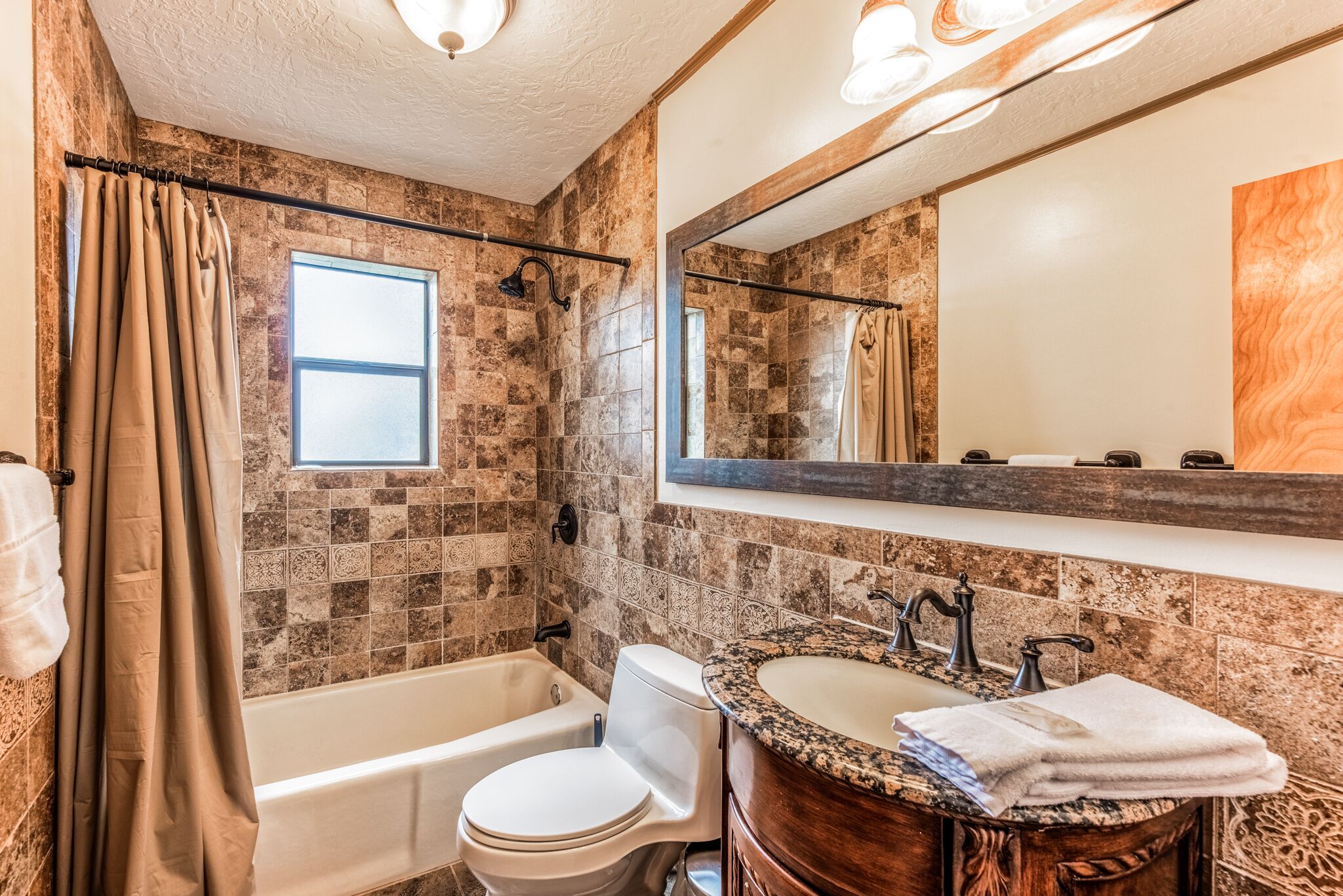 Une salle de bain équipée d’une baignoire, de toilettes et d’un meuble-lavabo avec un évier.