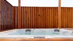 A hot tub with a wooden deck and a wooden fence in the background. - Hotel HW Libertad (Santiago)